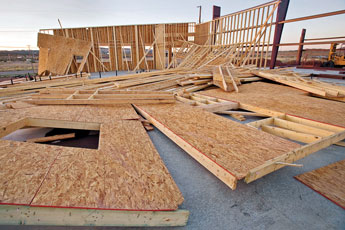 Large portions of the timber frame of Indian Hill Fire Station lie broken on the building's foundation Monday. The structure was severely damaged by Sunday's heavy winds. © 2011 Gallup Independent / Cable Hoover 